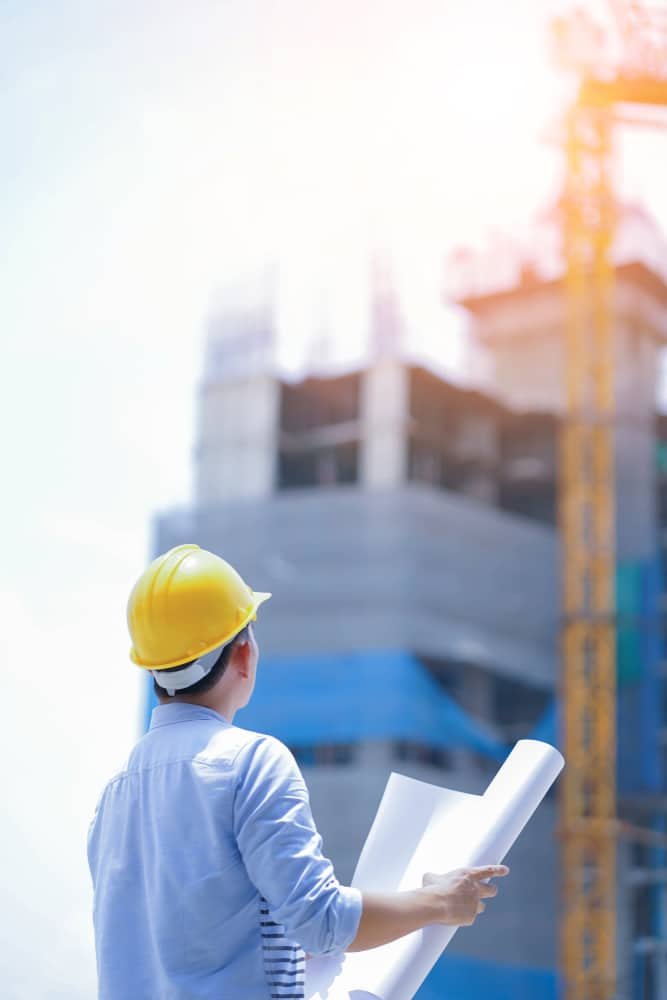 Portrait,Of,Engineer,Looking,A,Building,Site,Holding,A,Blueprints.